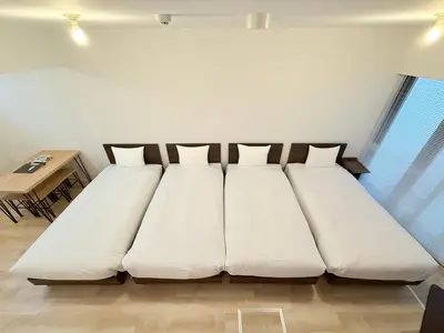 a large white bed in a room with a table at Lumiere Minami-Shinagawa B in Tokyo