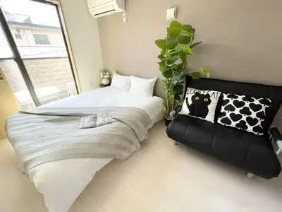 a bedroom with a bed and a potted plant at Comma House Kitaikebukuro 301 in Tokyo