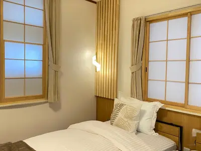 a bedroom with a bed and two windows at N28-Tokyo Shinjuku Luxury Villa 110 SPM in Tokyo