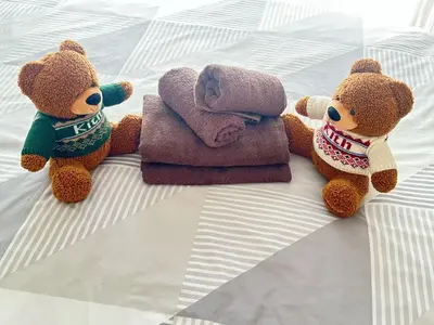 three stuffed teddy bears sitting on a bed at Shibuya\u306e\u5bbf in Tokyo