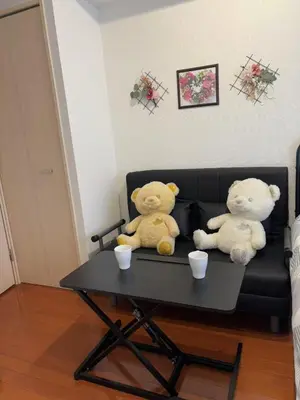two teddy bears sitting on a couch with cups on a table at Shibuya\u306e\u5bbf in Tokyo