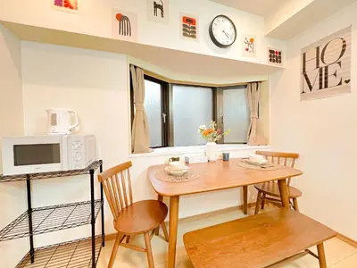 a dining room with a table and a microwave at Otsuka 2 double beds Apt, Free Wi-Fi in Tokyo