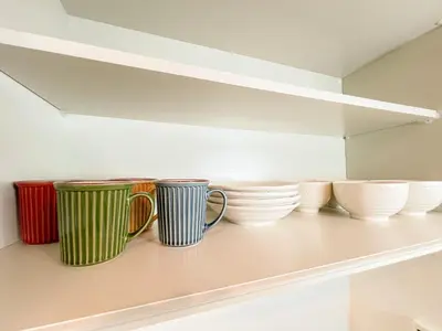 a row of cups and bowls sitting on a shelf at Otsuka 2 double beds Apt, Free Wi-Fi in Tokyo