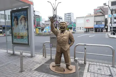 a statue of a man with his hand in the air at 5min walk to Kameari Station within 30min to Ginza, Asakusa, Skytree Direct bus to Haneda Airport & Tokyo Disneyland departing from Kameari Station in Tokyo