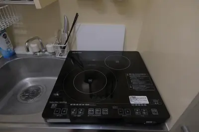 a microwave sitting on a counter next to a sink at 5min walk to Kameari Station within 30min to Ginza, Asakusa, Skytree Direct bus to Haneda Airport & Tokyo Disneyland departing from Kameari Station in Tokyo