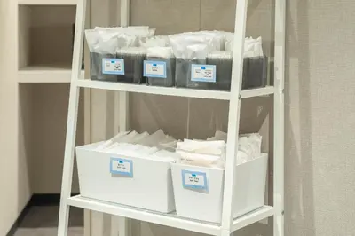 a shelf filled with lots of white towels at Tosei Hotel Cocone Kamata in Tokyo