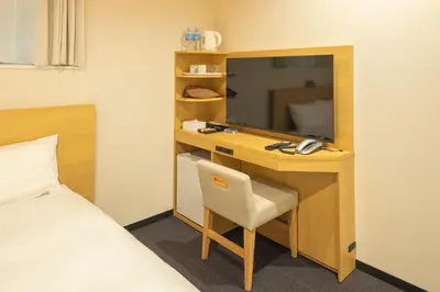 a room with a desk with a bed and a desk at Tosei Hotel Cocone Kamata in Tokyo