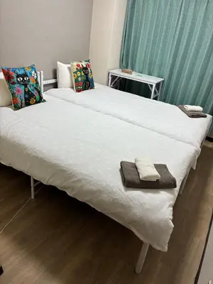 a large white bed with two towels on it at ksmst in Tokyo
