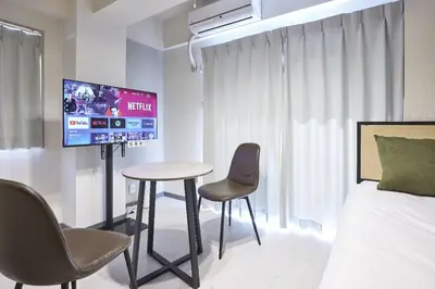 a bedroom with a bed and a table and chairs at \u30c8\u30ea\u30e0\u9762\u5f71\u6a4b in Tokyo