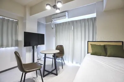 a bedroom with a bed and a table and chairs at \u30c8\u30ea\u30e0\u9762\u5f71\u6a4b in Tokyo