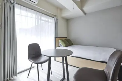 a small room with a bed and a table and chairs at \u30c8\u30ea\u30e0\u9762\u5f71\u6a4b in Tokyo