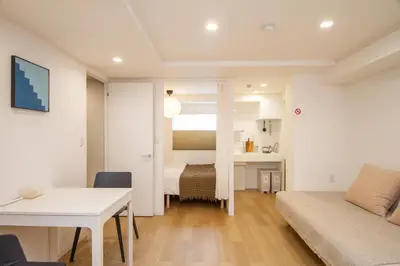 a small living room with a bed and a table and a couch at M House Tokyo Omori\u99c5 in Tokyo