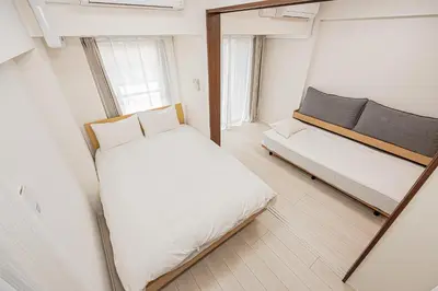 a small room with a bed and a mirror at Japan House \u5fa1\u5f92\u753a in Tokyo