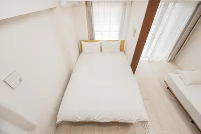 a bedroom with a large white bed in a room at Japan House \u5fa1\u5f92\u753a in Tokyo