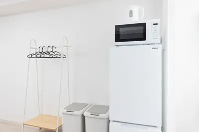 a kitchen with two trash cans and a microwave at Residence Shinamachi in Tokyo