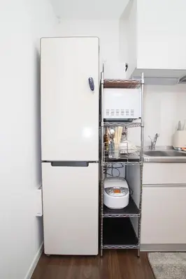 a white refrigerator in a kitchen with a shelf at \u4e1c\u4eac\u6c11\u5bbf \u5fa1\u7e01\u5bbf in Tokyo