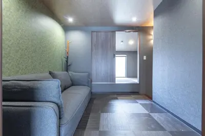 a living room with a couch and a mirror at Asakusa Miyabi no mori in Tokyo