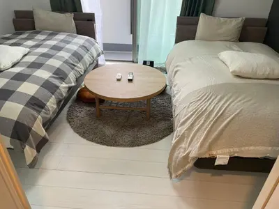 a room with two beds and a table between them at CAlMU ASAKUSA IMADO HOTEL ASAKUSA UENO IMADOZINZYA TOKYOSKYTREE HANEDA NARITA GINZA TOKYOSTATION Direct \u6d45\u8349\u4e0a\u91ce\u6771\u4eac\u30b9\u30ab\u30a4\u30c4\u30ea\u30fc \u6210\u7530\u7a7a\u6e2f\u7fbd\u7530\u7a7a\u6e2f\u6771\u4eac\u99c5\u76f4\u884c\u30d0\u30b9\u96fb\u8eca\u4fbf\u5229 in Tokyo