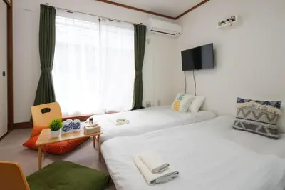 two twin beds in a room with a window at \u5927\u4eba\u6c17\u30a8\u30ea\u30a2\u65b0\u5bbf\u307e\u3067\u96fb\u8eca4\u5206 Jr\u6771\u4e2d\u91ce\u99c5\u5f92\u6b696\u5206 \u5927\u4e45\u4fdd\u99c5\u5f92\u6b6910\u5206 \u6700\u59275\u540d\u69d8 \u304a\u8377\u7269\u9810\u53ef in Tokyo