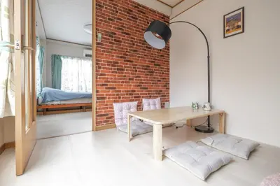 a dining room with a table and a brick wall at Minowa Sta Direct to Ueno in Tokyo