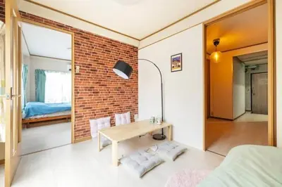 a bedroom with a table and a brick wall at Minowa Sta Direct to Ueno in Tokyo