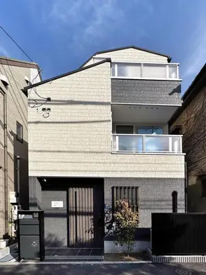 a white brick building with a black door at BRD2143 New built properties 2 mins walk to Shin-Okubo in Tokyo