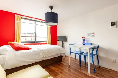 a red and white bedroom with a bed and a desk at jtr\u6d45\u8349\u6a4b301 in Tokyo