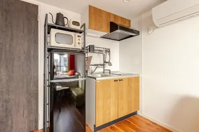 a kitchen with a stainless steel refrigerator and a microwave at jtr\u6d45\u8349\u6a4b301 in Tokyo