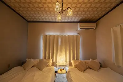 a bedroom with two beds and a window with a chandelier at ODYSSEY Tokyo Skytree in Tokyo