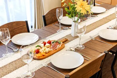 a wooden table with a plate of food and wine glasses at ODYSSEY Tokyo Skytree in Tokyo