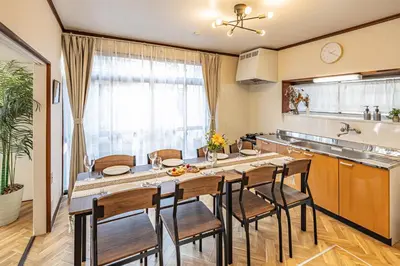 a kitchen with a large wooden table and chairs at ODYSSEY Tokyo Skytree in Tokyo