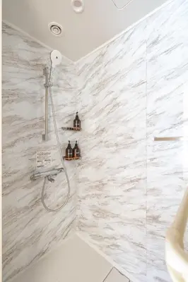 a bathroom with a shower with white marble tiles at \u65b0\u5bbf\u6238\u5efa\u30666 in Tokyo