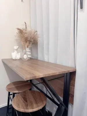 a wooden table with two chairs and a vase on it at Ueno Rose in Tokyo