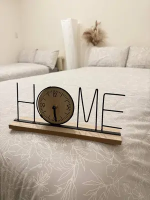 a clock sitting on top of a bed with the word mum at Ueno Rose in Tokyo
