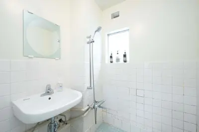a white bathroom with a sink and a mirror at Shibuya Station 8-min walk, Shibuya Center, 3 people stay, WIFI, 4F No elevetor in Tokyo