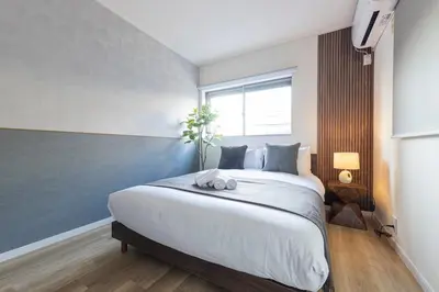 a bedroom with a large white bed with a window at \u3077\u3075\u304b\u30b7\u30bf\u30e4\u516b\u5e83 in Tokyo