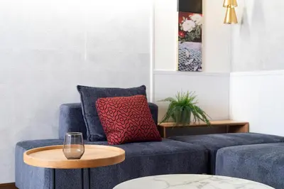 a blue couch with a red pillow and a wooden table at \u3077\u3075\u304b\u30b7\u30bf\u30e4\u516b\u5e83 in Tokyo