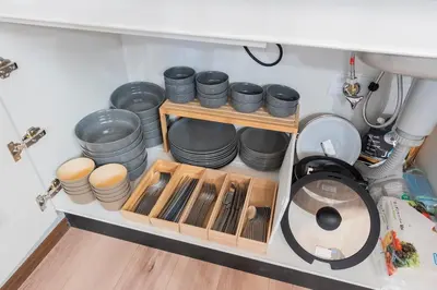 a shelf with plates and bowls and a sink at \u3077\u3075\u304b\u30b7\u30bf\u30e4\u516b\u5e83 in Tokyo