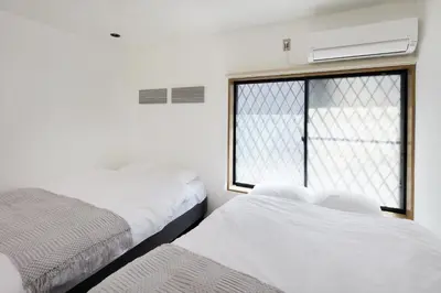 two beds in a room with a window at \u548c\u6c23\u4f1a\u3005\u6d45\u8349\u6a4b Wakiaiai Asakusabashi in Tokyo