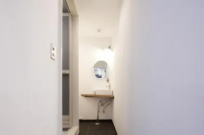 a hallway with a mirror and a sink in a room at \u548c\u6c23\u4f1a\u3005\u6d45\u8349\u6a4b Wakiaiai Asakusabashi in Tokyo