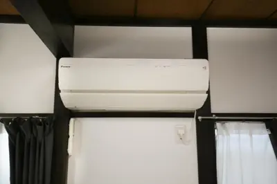 a white air conditioner in a room with curtains at Full facilities 9PPL CozyHouse1 stop-Yamanote Line in Tokyo