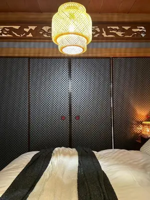 a bedroom with a bed and a chandelier at nagomi\u5eb5 in Tokyo