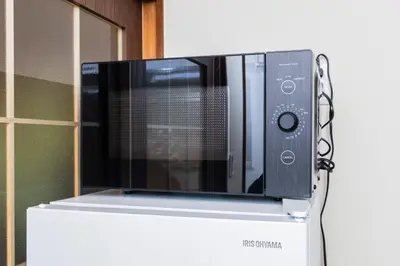 a microwave sitting on top of a white refrigerator at nagomi\u5eb5 in Tokyo