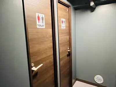 a wooden elevator door with a sign on it at Hinode Kagurazakaekimae Hotel in Tokyo