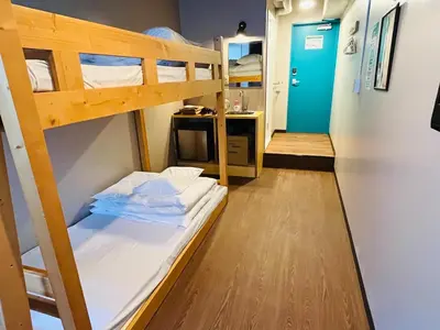 a room with two bunk beds and a hallway at Hinode Kagurazakaekimae Hotel in Tokyo