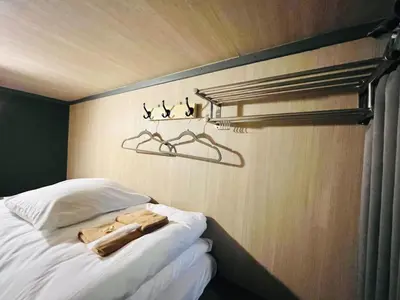 a bedroom with a bed with birds on the wall at Hinode Kagurazakaekimae Hotel in Tokyo