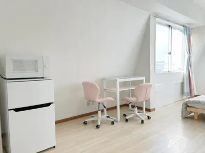 a kitchen with two pink chairs and a microwave at Ikebukuro center#\u6c60\u888b\u4e2d\u5fc3#\u9ad8\u7ea7\u9633\u5149\u516c\u5bd3\u8f66\u7ad9\u6b65\u884c5\u5206#\u9ad8\u901fwifi#\u667a\u80fd\u9a6c\u6876\u5e72\u6e7f\u5206\u79bb1201 in Tokyo