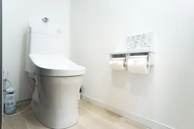 a white toilet in a bathroom with a clock on the wall at Near Asakusa and Ueno, Spacious 3BR House, Max 8 People in Tokyo