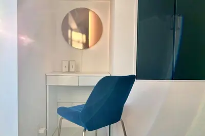 a blue chair in a room with a mirror at Near Asakusa and Ueno, Spacious 3BR House, Max 8 People in Tokyo