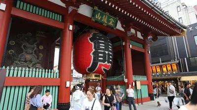 people walking in front of a building with a red at Near Asakusa and Ueno, Spacious 3BR House, Max 8 People in Tokyo